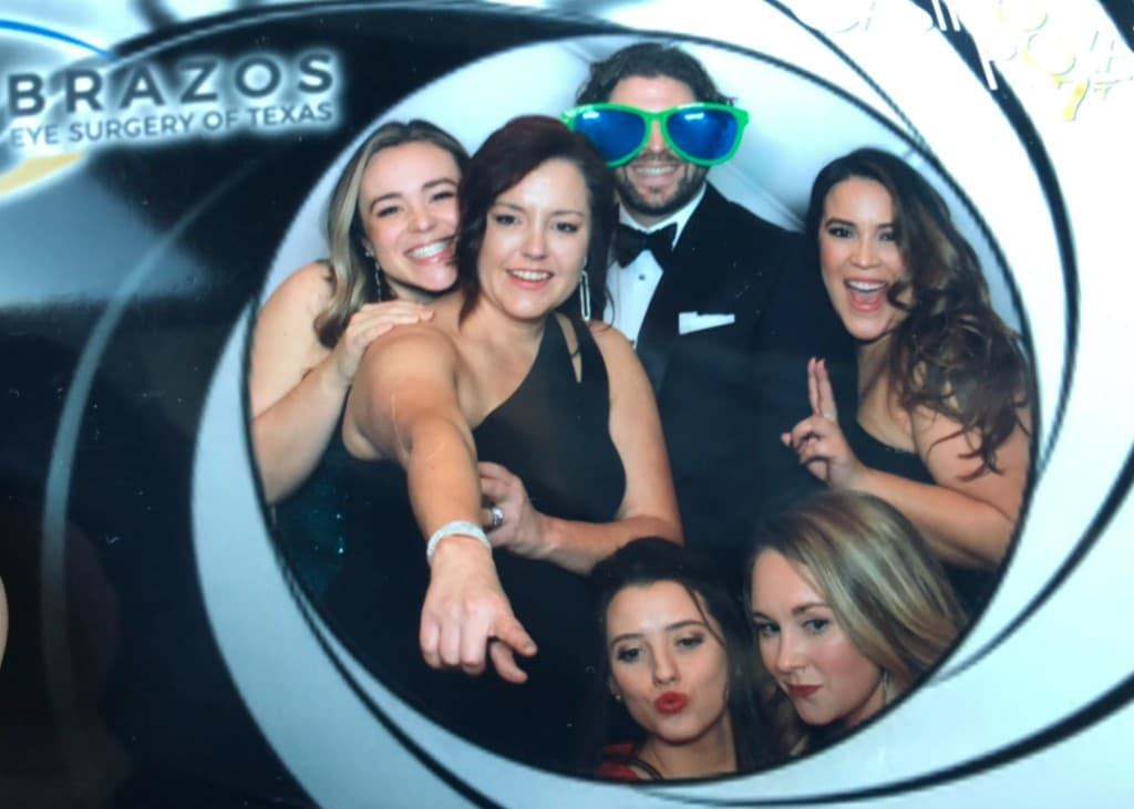 Brazos Eye team having fun in a photo booth at a company event